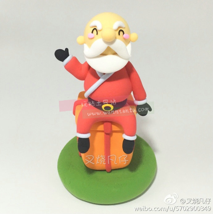 坐在礼物盒上的粘土圣诞老人玩偶